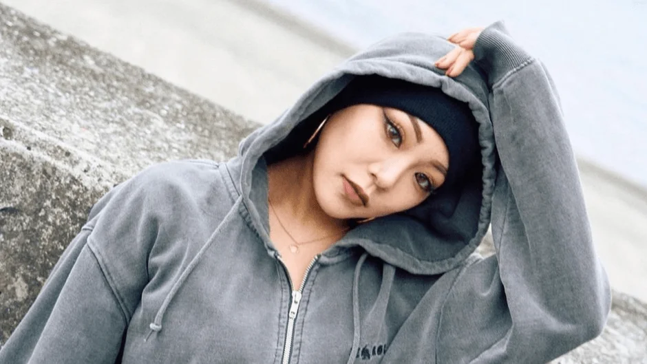 グレーのパーカーと黒いビーニーを着用した女性のポートレート