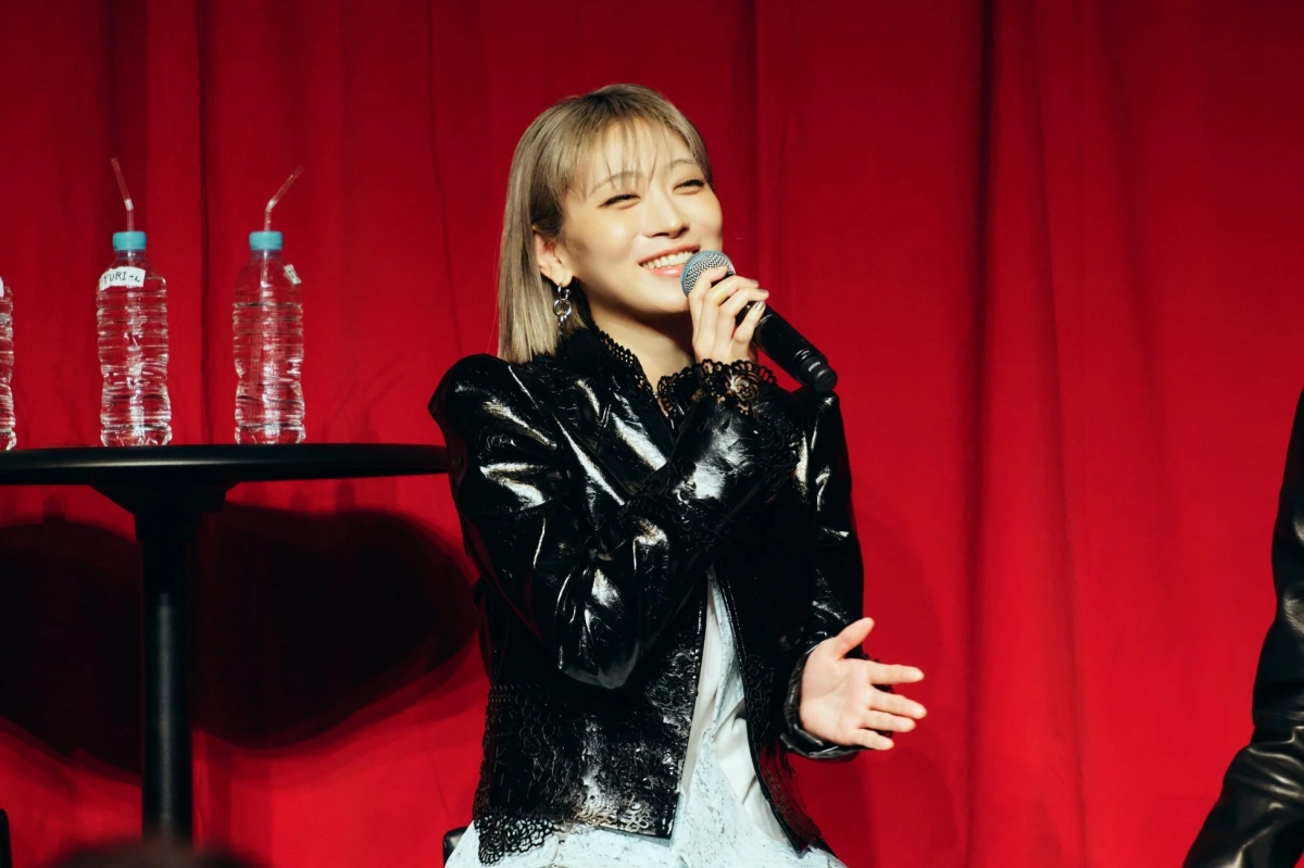 マイクを持って笑顔で話すHANAメンバー