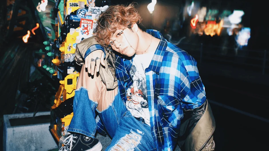 ストリートファッションの男性が座っている夜の街角のポートレート