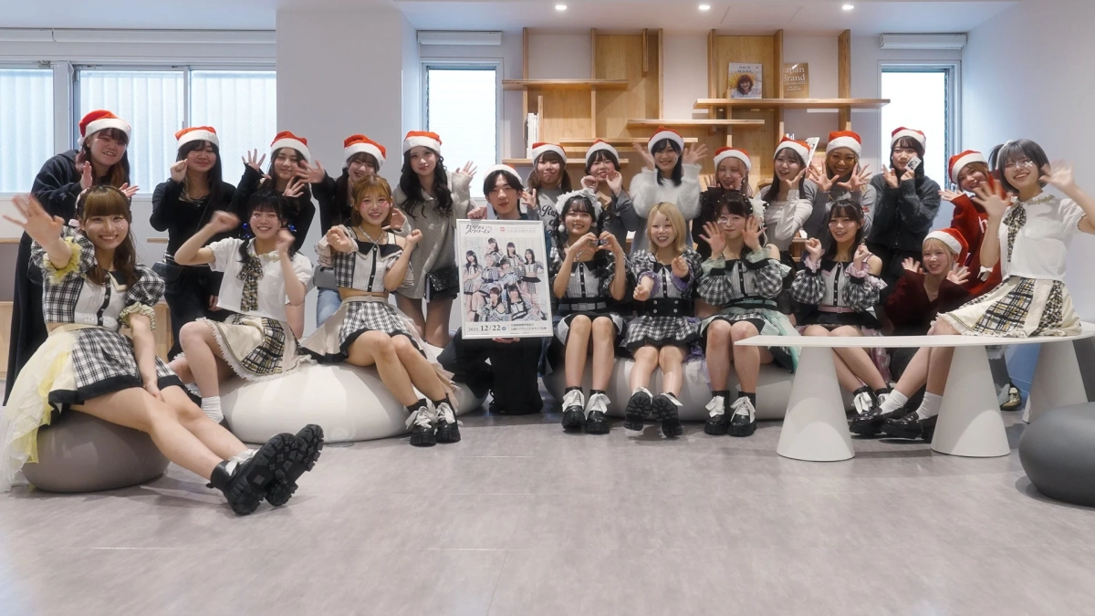サンタ帽をかぶったアイドルグループの集合写真