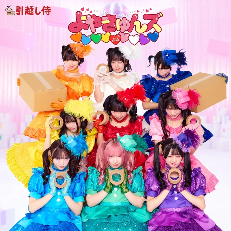 「引越し侍」と「よやきゅんず」のコラボレーション広告で、カラフルなドレスをまとった女性アイドルグループがダンボール箱やガムテープを持ってポーズをとっています。明るくポップな雰囲気の画像です。