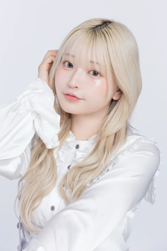 白いフリルブラウスを着た金髪の女性