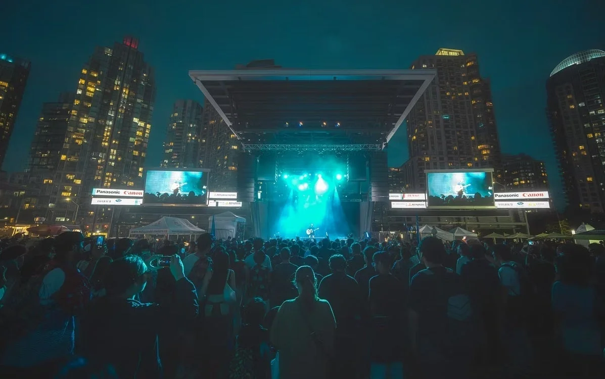 夜の屋外コンサート会場で、青い照明が輝くステージ