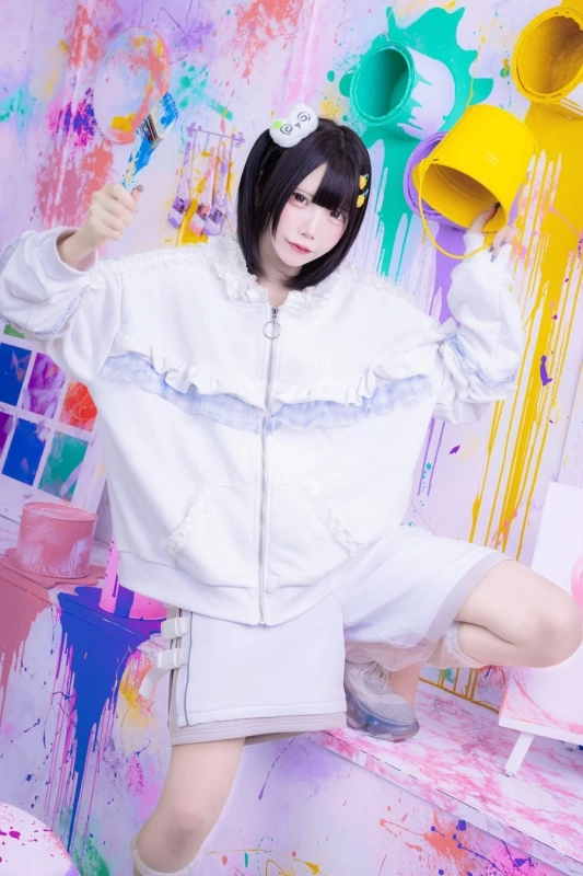 白いフリルのパーカーとショートパンツを身につけた女性