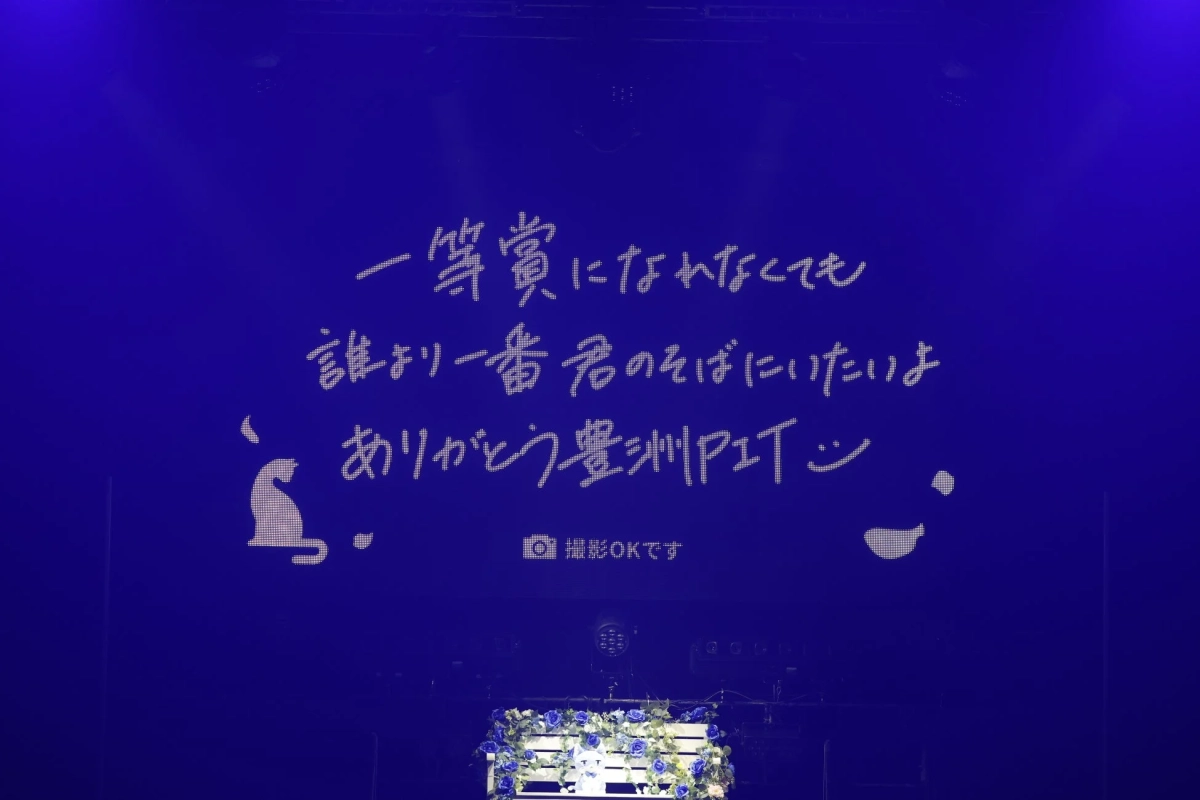 青いスクリーンに「一等賞になれなくても誰より一番君のそばにいたいよ ありがとう豊洲PIT :)」というメッセージが表示されている様子