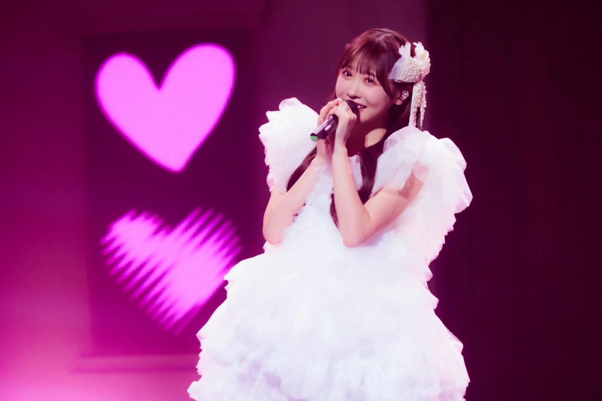 白いドレスの櫻井優衣がマイクを持って歌唱するステージの様子