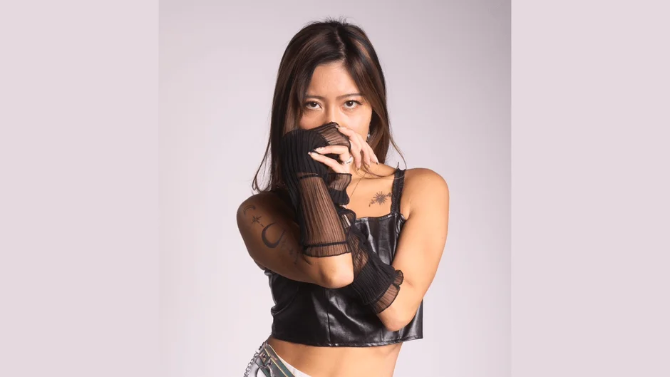 黒いクロップトップとシアーなアームウォーマーを着た若い女性のポートレート