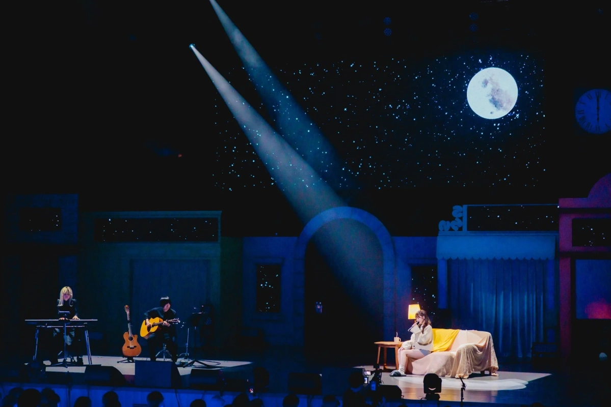 星空と満月を背景にした幻想的なステージで、3人のミュージシャンが演奏するライブの様子