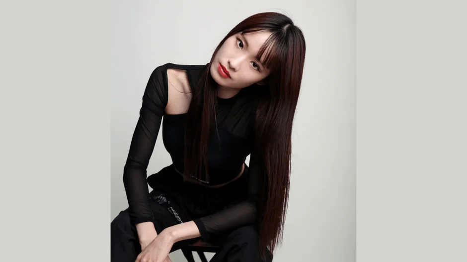 黒いシアーなトップスとパンツを着用したロングヘアの女性のポートレート