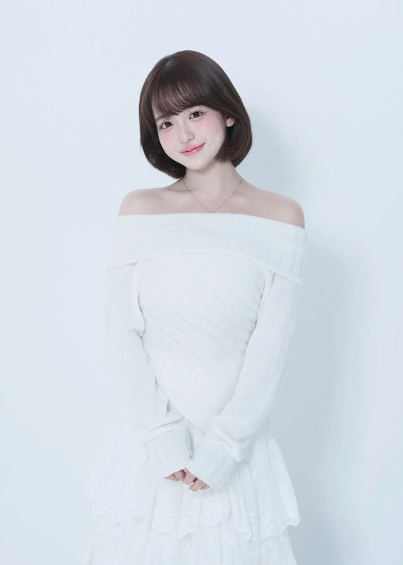 白いオフショルダーのセーターを着たショートヘアの女性