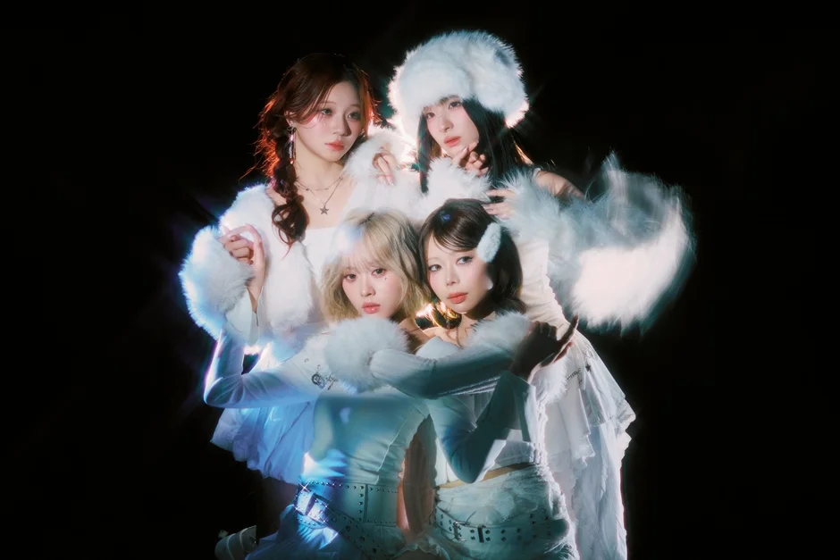 暗い背景に白いファーの衣装をまとった4人の女性