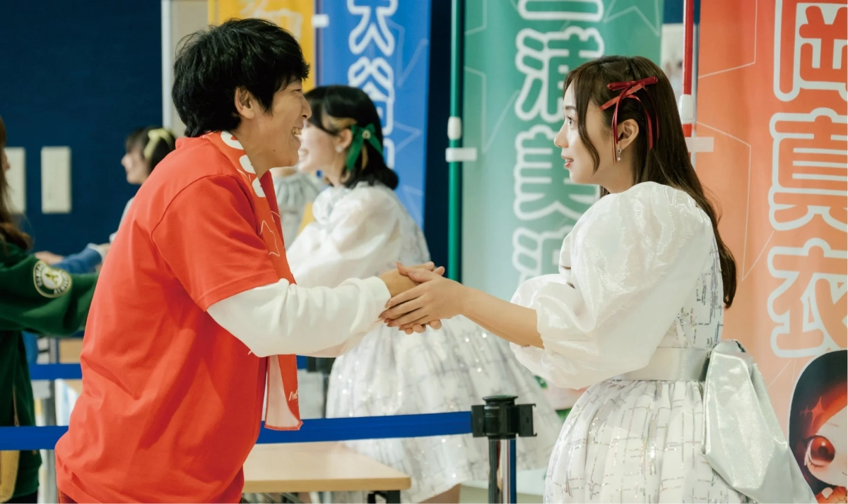 イベント会場で握手する男女