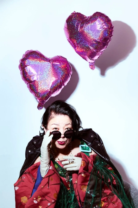 サングラスをかけた女性が、ライダースジャケットと着物風の衣装を個性的に着こなしている