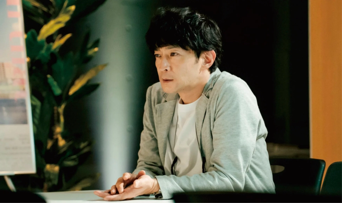 会議室のような場所で座る男性