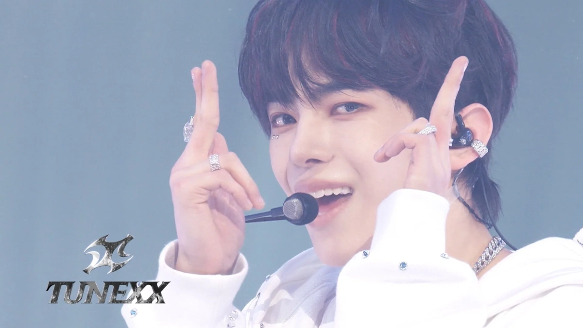 ステージで笑顔を見せる若い男性アイドル