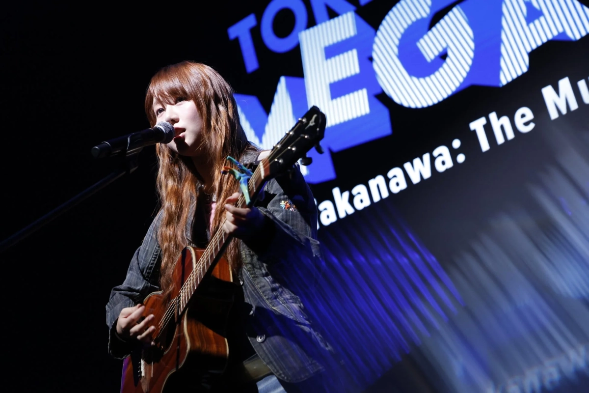 ふみのさんがアコースティックギターを弾きながら歌う様子