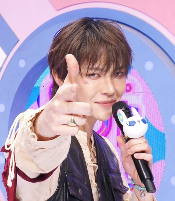 カラフルなステージでポーズをとるK-POPアイドル3人