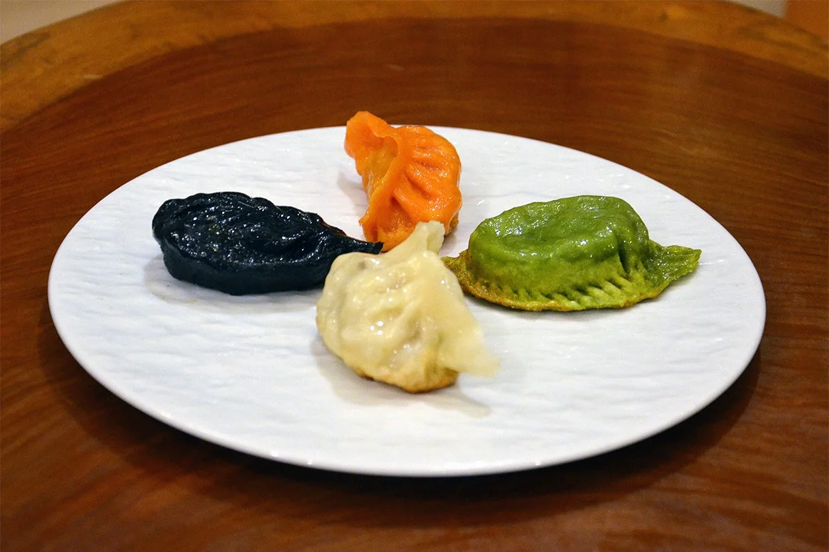 白い皿に盛られたカラフルな餃子