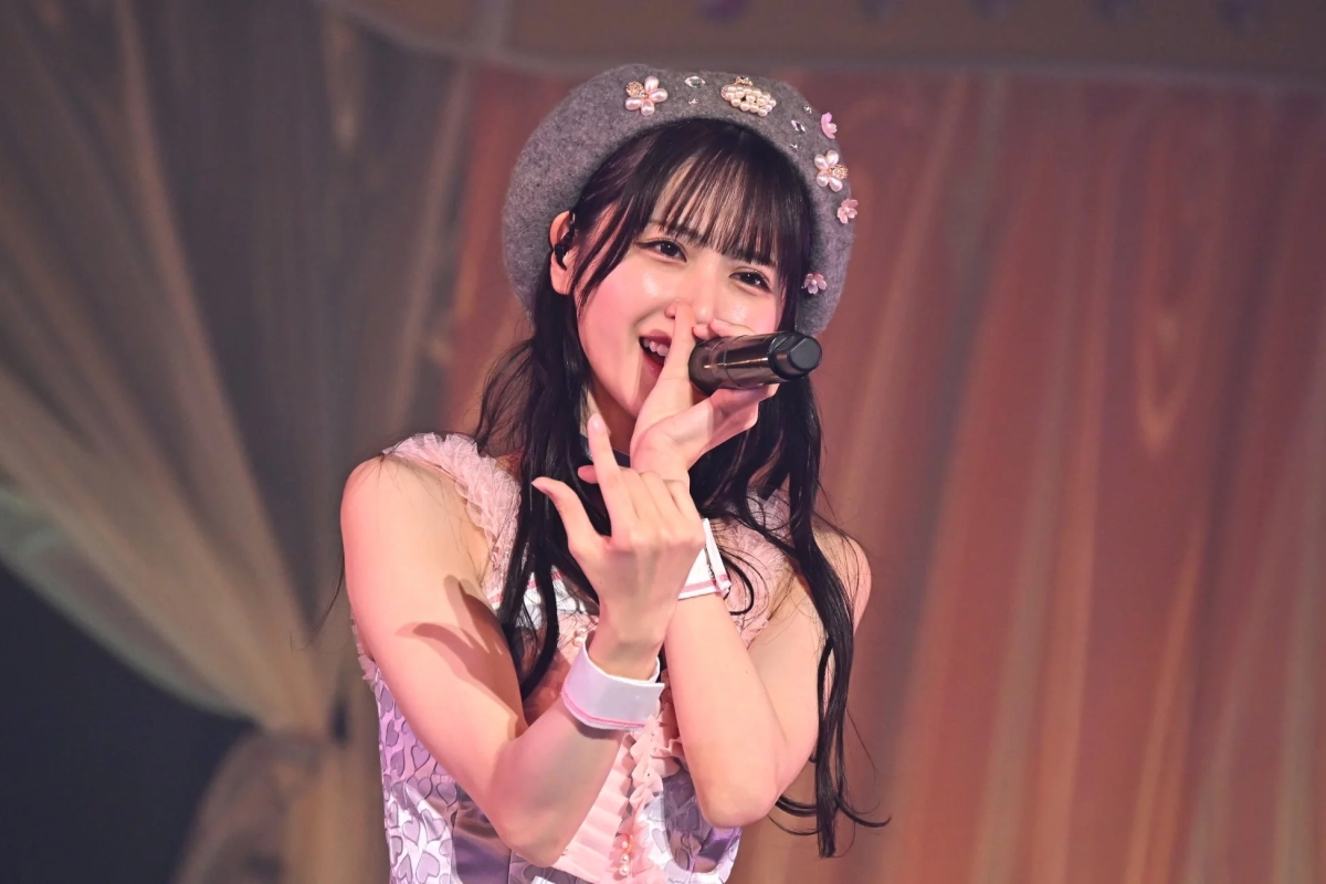 ステージ上でマイクを手に歌う若い女性