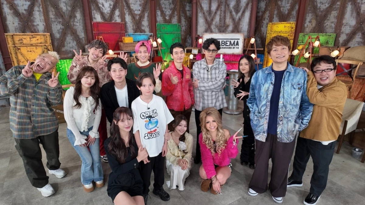 スタジオで約15名の男女が笑顔でポーズをとっている集合写真