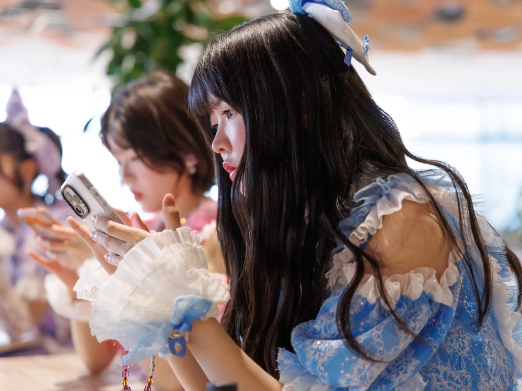 青と白の衣装のメンバーがスマホ操作