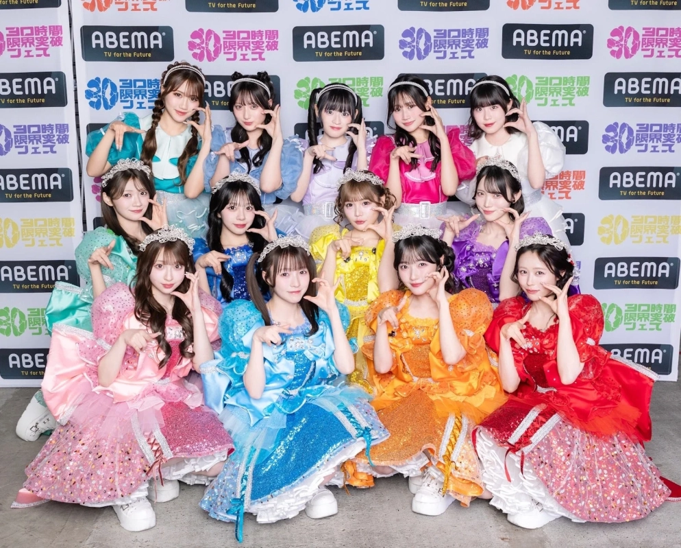 ABEMAの「30日間 限界突破 フェス」ロゴを背景に、カラフルなプリンセス風衣装を着た女性アイドルグループが集合。可愛らしいポーズと笑顔で、華やかで楽しいイベントの雰囲気を伝えている。