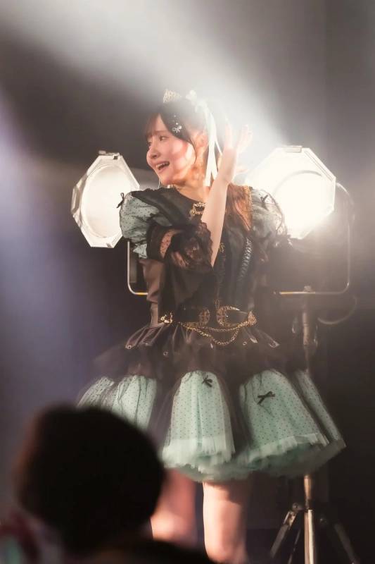 ステージで笑顔を見せるアイドル