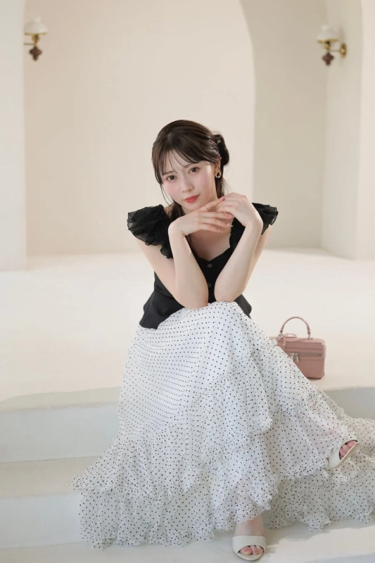 明るい室内の白い階段に座る女性のポートレート