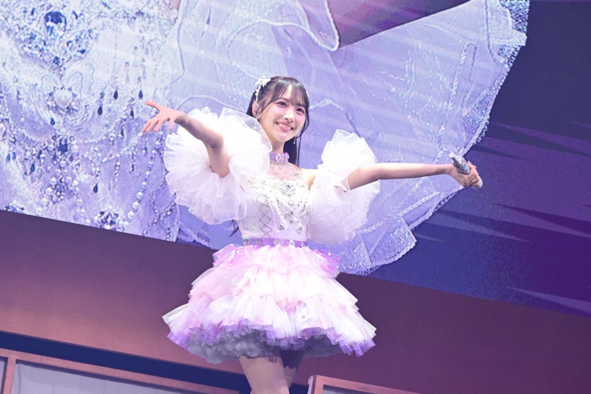 白とピンクのドレス姿で歌唱