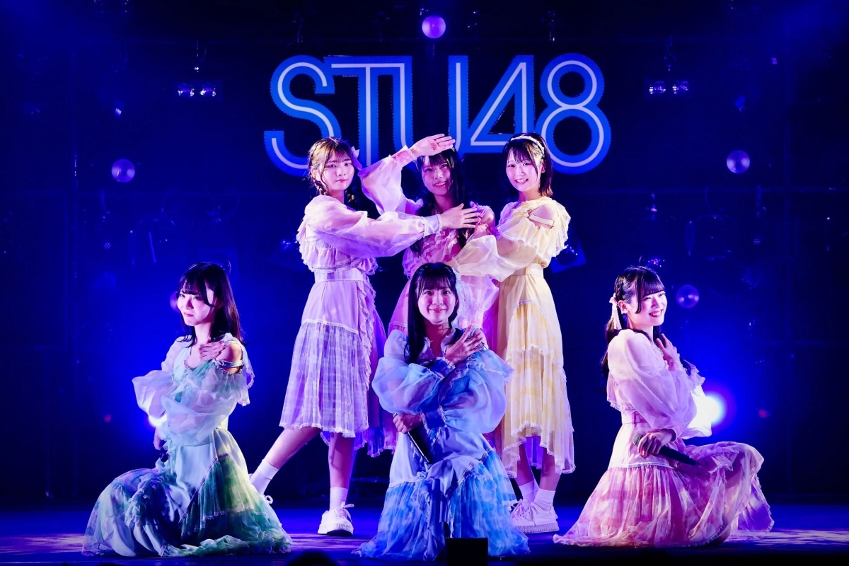 STU48のメンバー6人がライブステージでパフォーマンスを行っている様子です。パステルカラーの華やかな衣装を身につけ、笑顔でポーズをとっており、ステージ背景にはグループ名「STU48」のロゴが大きく表示されています。