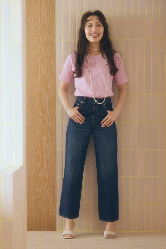 ピンクのTシャツとデニムのワイドパンツを着用した女性
