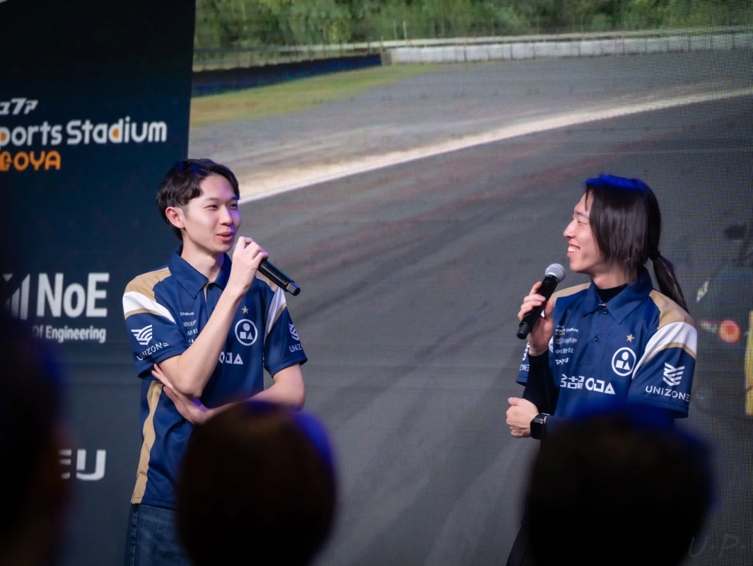 ステージ上の2人の男性とスクリーン