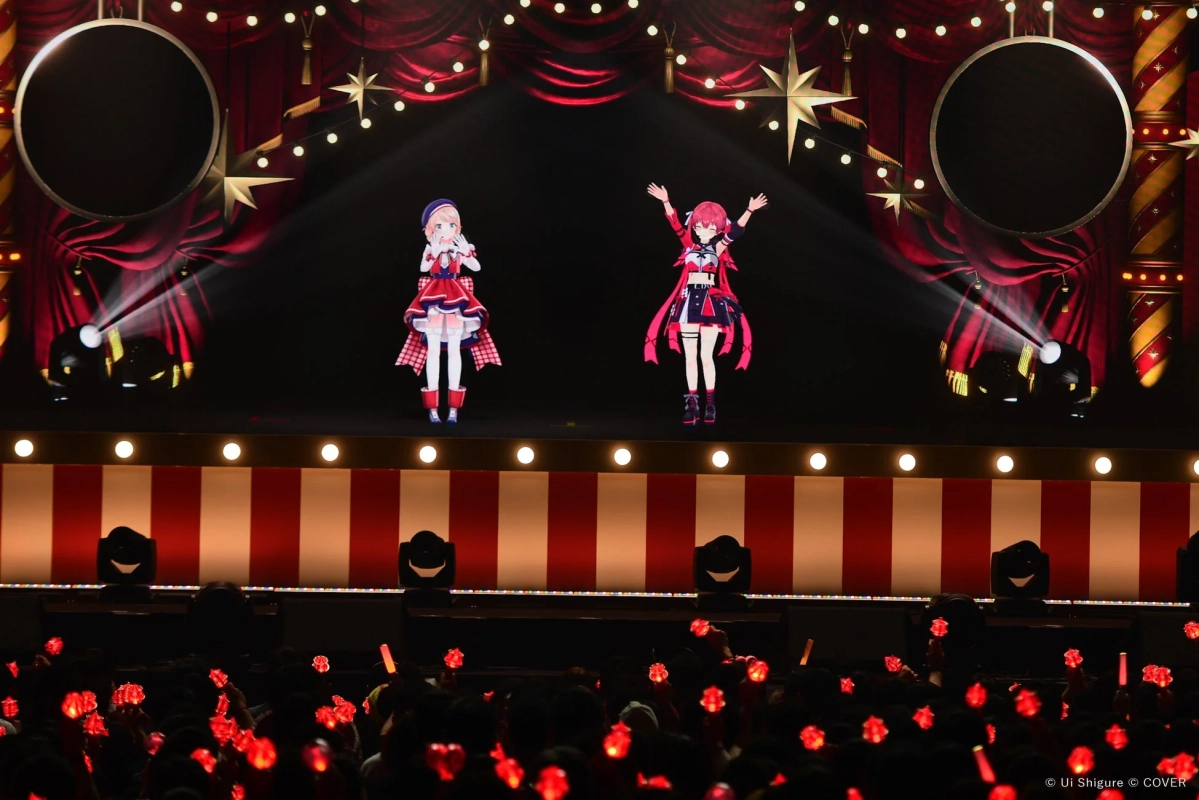 バーチャルアイドルの二人が華やかなサーカス風のステージでパフォーマンスを行っています。