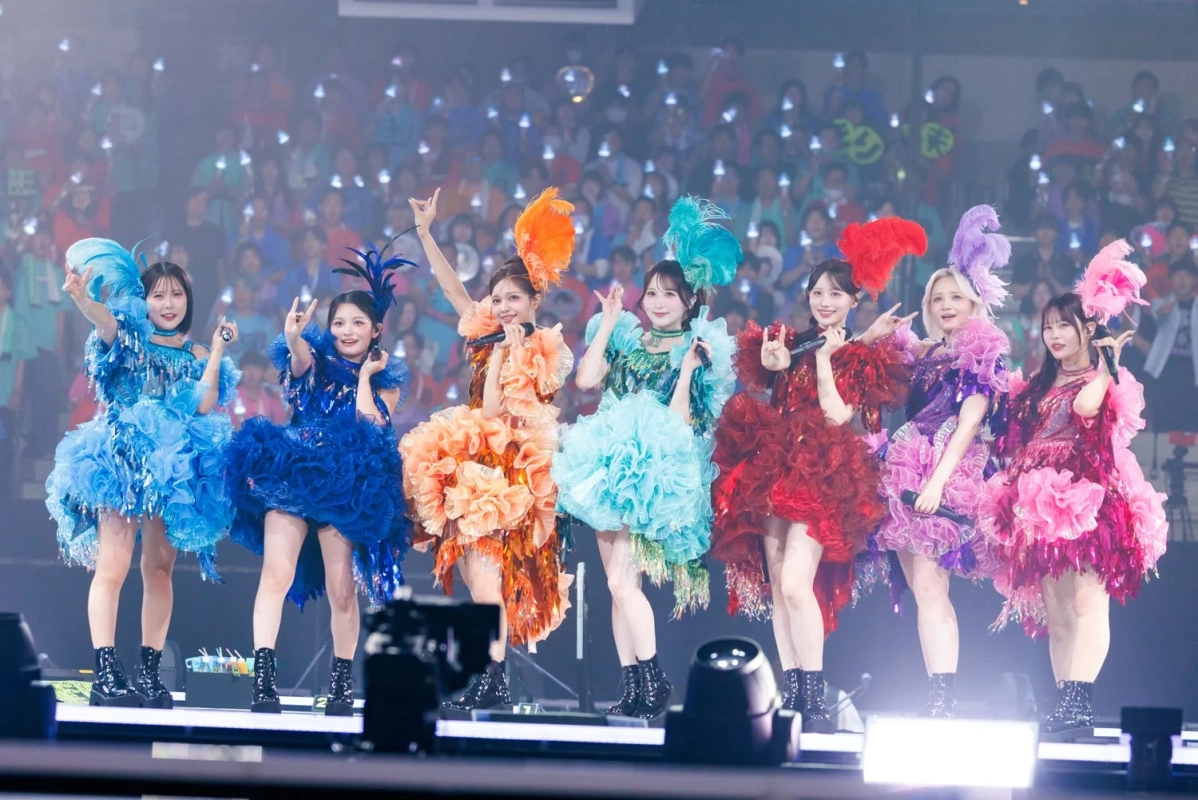 アイドルグループがカラフルな衣装でステージパフォーマンス