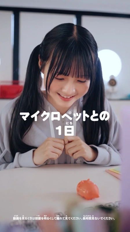 テーブルの上のマイクロペットを見る小杉怜子さん