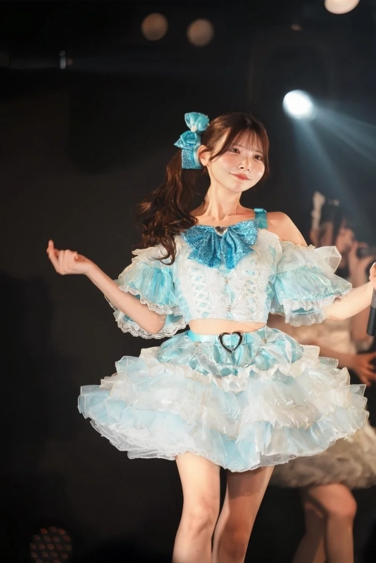 青と白のフリルのアイドル衣装でポーズをとる女性