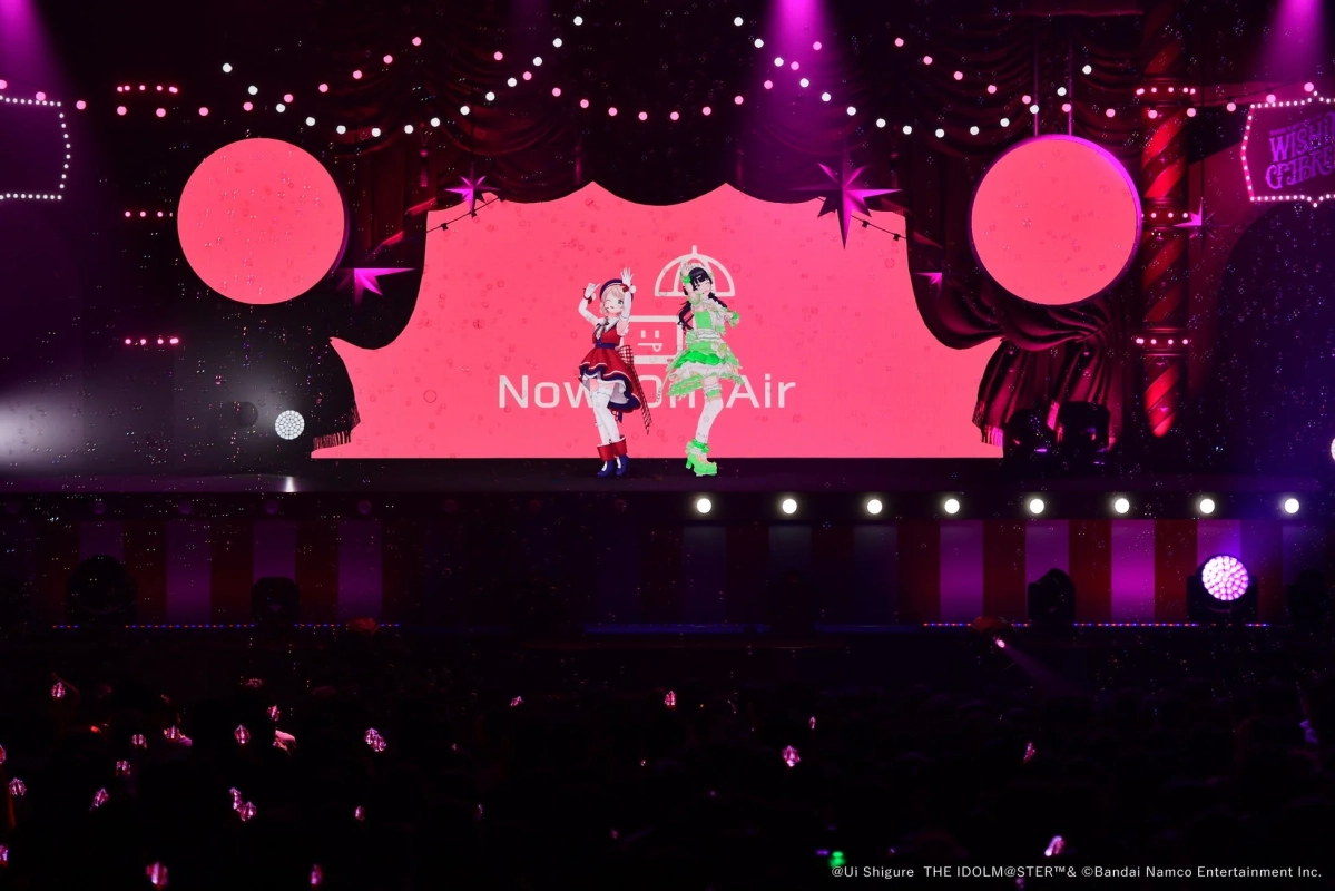 ピンクのスクリーンに「Now On Air」と表示されたステージで、2人のバーチャルアイドルがパフォーマンスを披露しています。