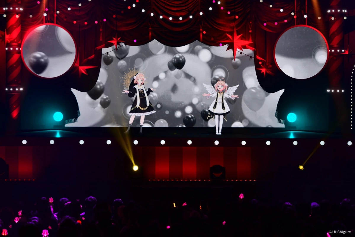華やかなステージで2人のバーチャルキャラクターがパフォーマンスをしている様子。