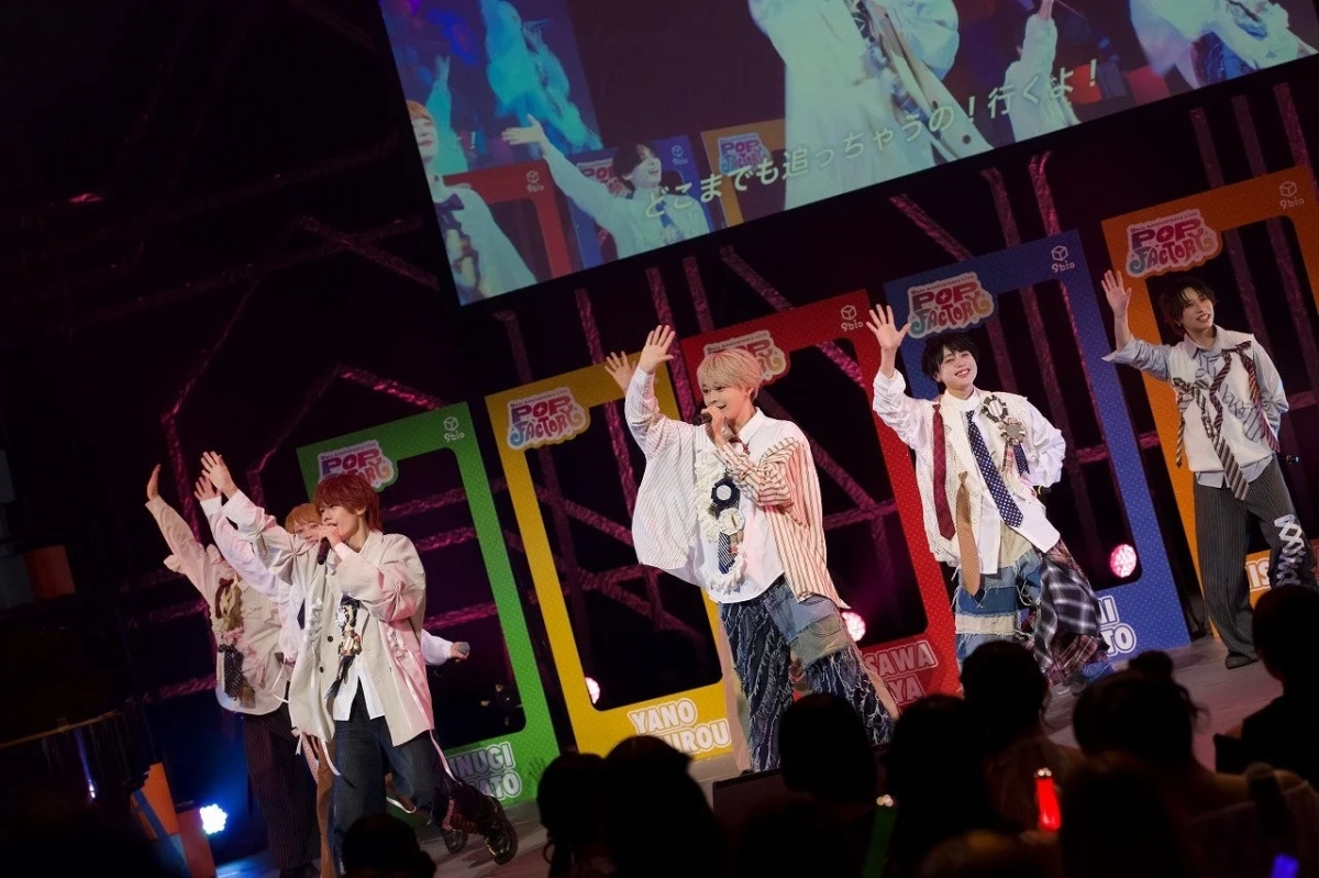 ライブステージで観客に手を振るメンバー