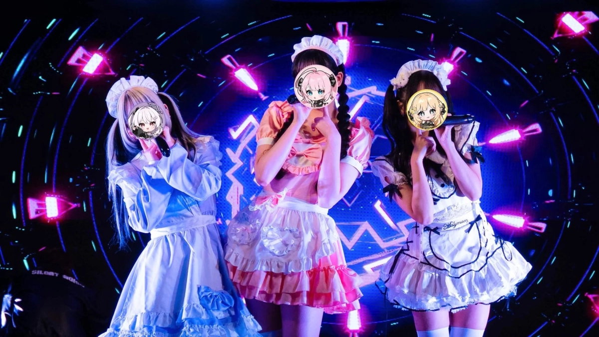 メイド服を着た3人の女性がステージでパフォーマンス