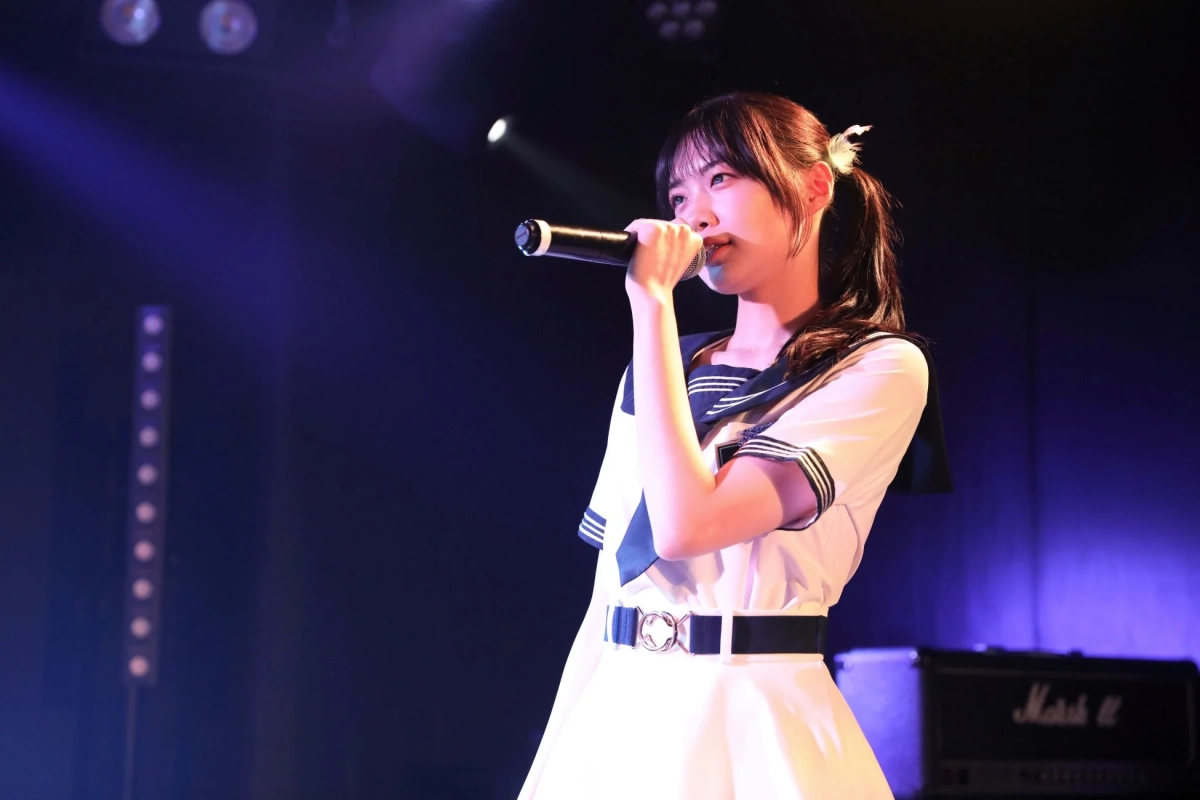 青い照明の中で歌うアイドル