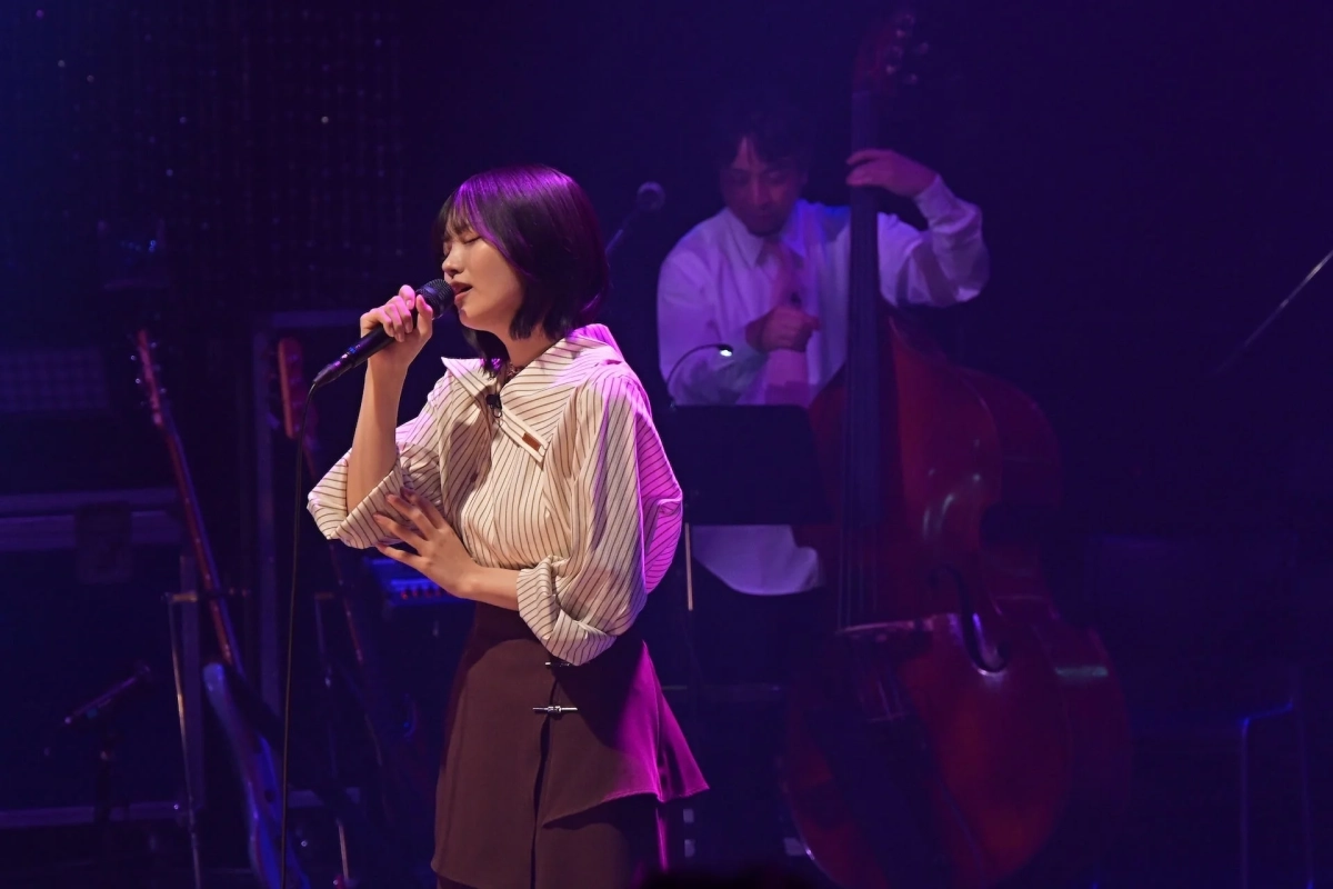 中西アルノがベース奏者と共に歌唱する様子