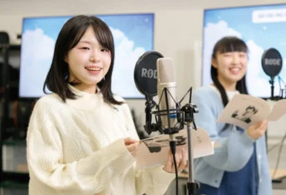 レコーディングスタジオでマイクに向かう女性たち