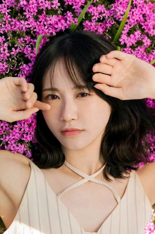 ピンク色の芝桜が咲き誇る中で寝そべる若い女性のポートレート。