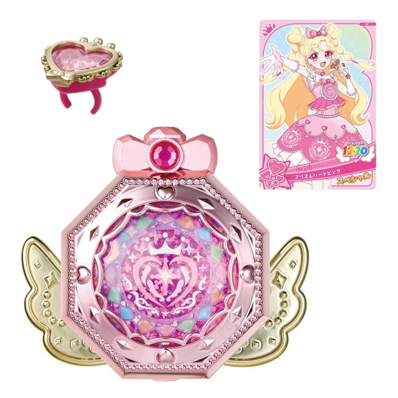 ピンク色の変身コンパクト型玩具、ハートのリング、そしてアイドル風のキャラクターが描かれたカードがセットになった商品です。キラキラとした装飾が特徴で、魔法少女のような世界観を表現しています。