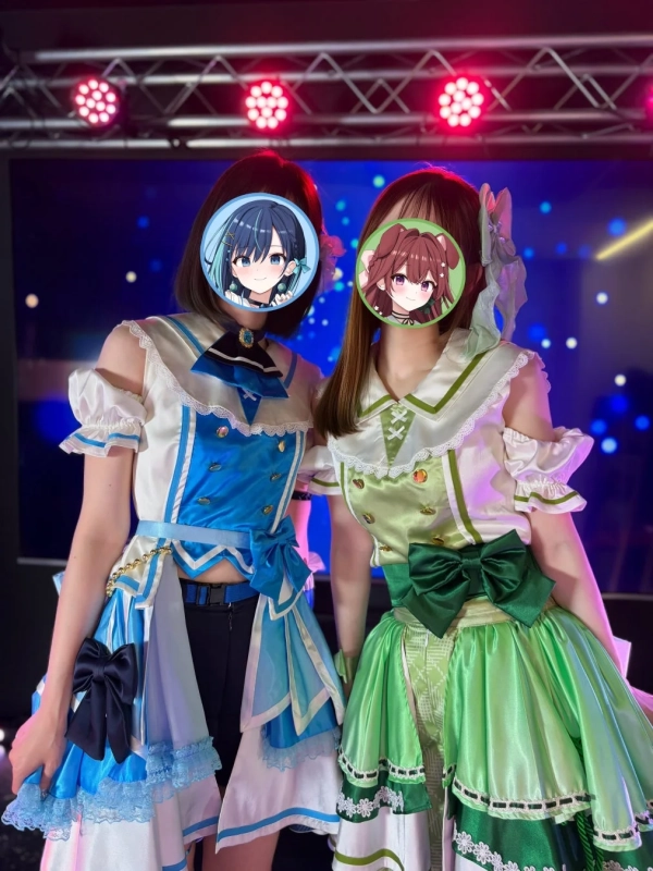 ライブステージでポーズをとる二人