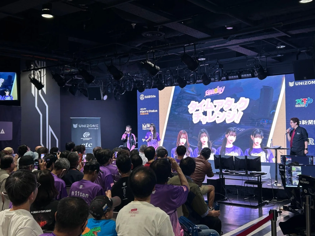 eスポーツイベントの会場で、ステージ上の大画面にアイドルグループSKE48と「タイムアタックチャレンジ」の文字が表示されている。