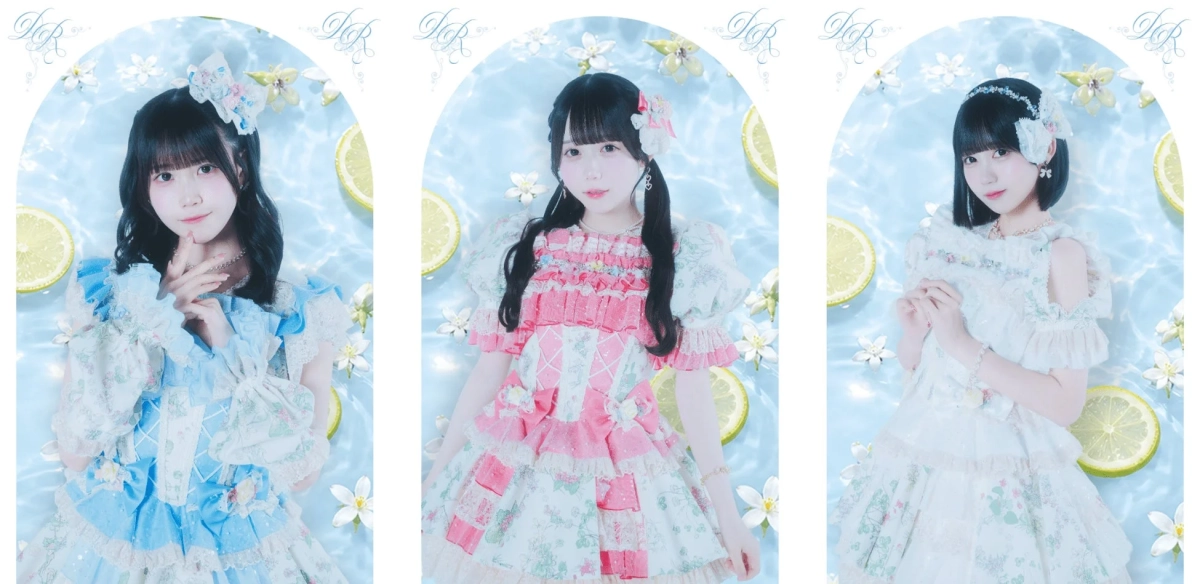 水面にレモンと花が浮かぶ背景で、パステルカラーのロリータ風ドレスを着た3人の女性がポーズをとっている。