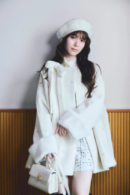 白いコートとハンドバッグを着用した守屋麗奈さん